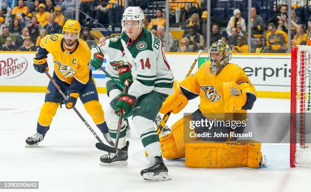 Joel Eriksson Ek of the Minnesota Wild battles in front of the net against Roman Josi and Juuse Saros of the Nashville Predators during an NHL game...