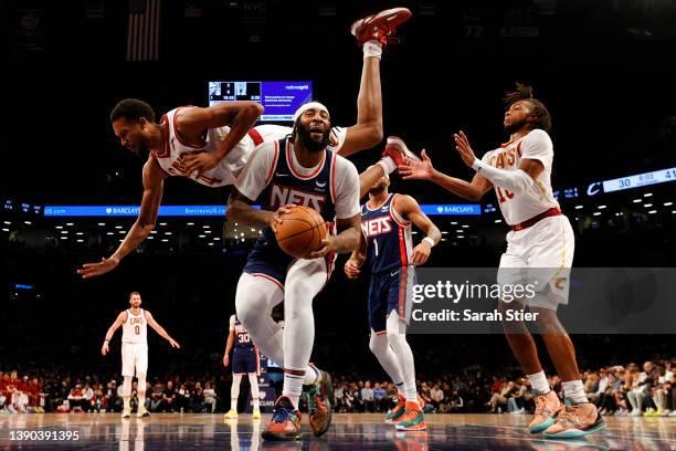 Evan Mobley of the Cleveland Cavaliers falls over Andre Drummond of the Brooklyn Nets as he goes to the basket during the game at Barclays Center on...