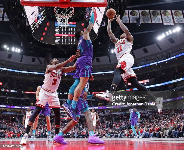 DeMar DeRozan of the Chicago Bulls shoots over Miles Bridges of the Charlotte Hornets and teammate Tristan Thompson at the United Center on April 08,...