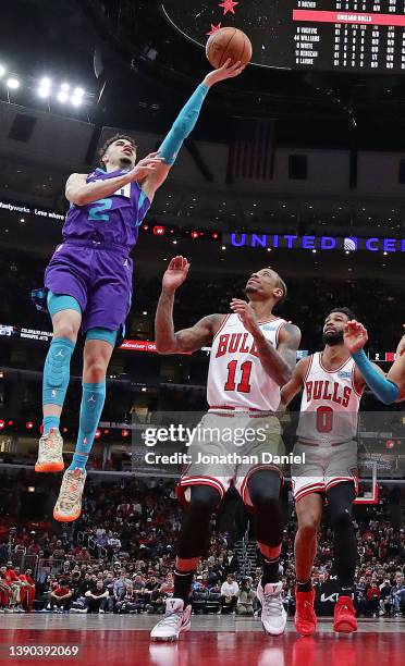 LaMelo Ball of the Charlotte Hornets shoots over DeMar DeRozan and Coby White of the Chicago Bulls at the United Center on April 08, 2022 in Chicago,...