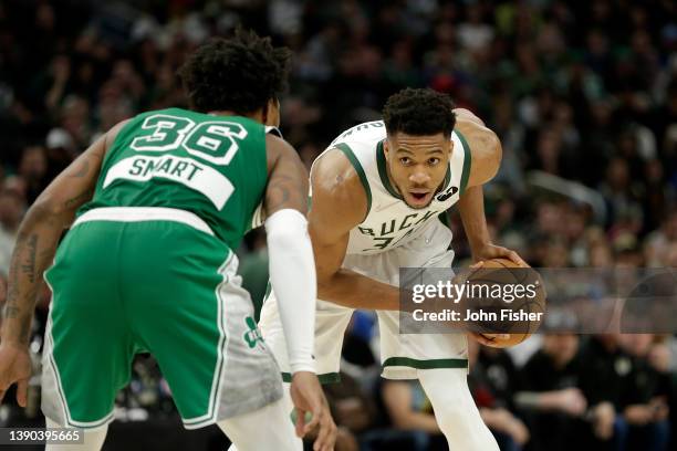 Giannis Antetokounmpo of the Milwaukee Bucks looks to drive on Marcus Smart of the Boston Celtics during the second half of a game at Fiserv Forum on...