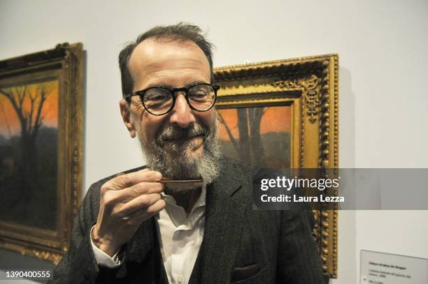 The Curator Sergio Rebora combs his beard after taking off his anti Covid mask to pose for a photograph during the opening of the exhibition 'Vittore...