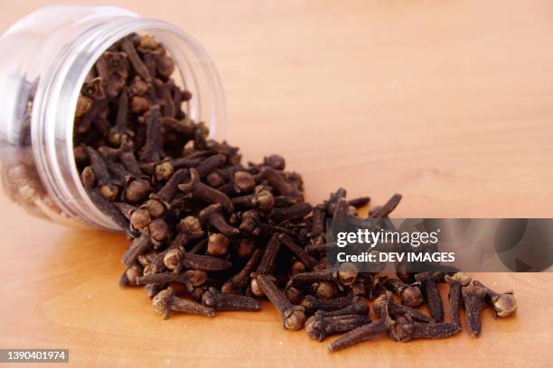 cloves spilled out of bottle - clove stock pictures, royalty-free photos & images