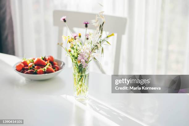 wildflower and strawberries at kitchen table. - morning kitchen stock pictures, royalty-free photos & images