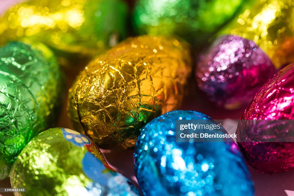Colored chocolate easter eggs wrapped with green, yellow and blue foil
