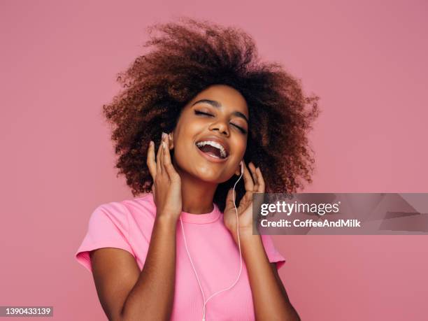 photo of young curly girl with headphones - curly brown hair stock pictures, royalty-free photos & images