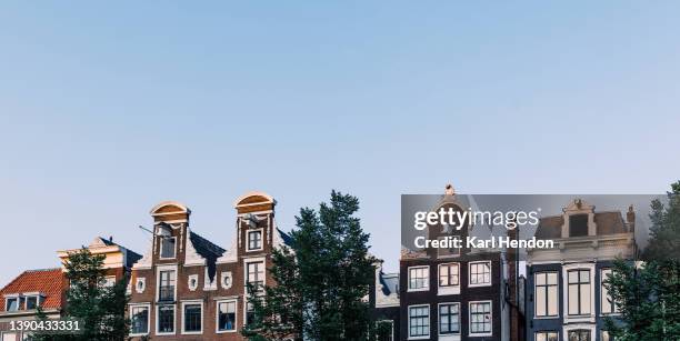 a sunset view of amsterdam buildings - amsterdam blue sky stock-fotos und bilder