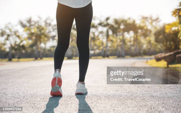 woman feet running on road closeup on shoe. young fitness women runner legs ready for run on the road. sports healthy lifestyle concept - woman running shorts stock pictures, royalty-free photos & images