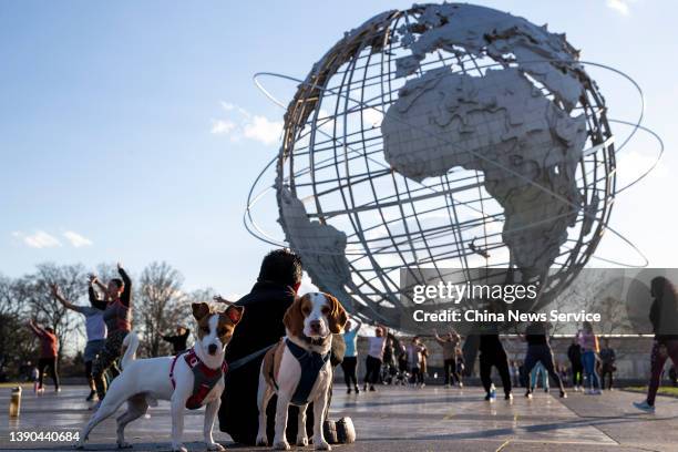 People dance near the Unisphere at Flushing Meadows Corona Park on April 8, 2022 in New York City.