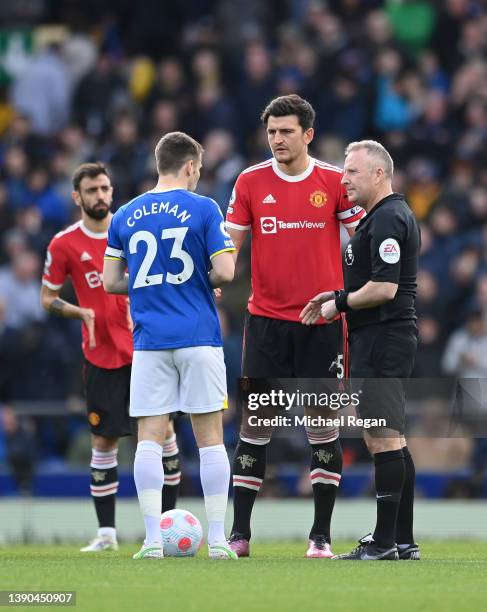 Seamus Coleman of Everton and Harry Maguire of Manchester United interact with Match Referee, Jonathan Moss prior to the Premier League match between...