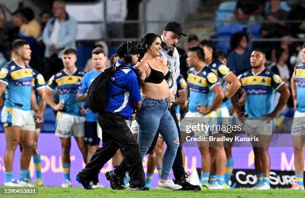 Pitch invader is taken from the field by security guards during the round five NRL match between the Gold Coast Titans and the Parramatta Eels at...