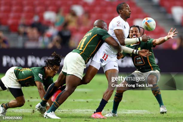 Perry Baker of the United States runs with the ball against Dewald Human, Siviwe Soyizwapi and Selvyn Davids of South Africa in their pool match...
