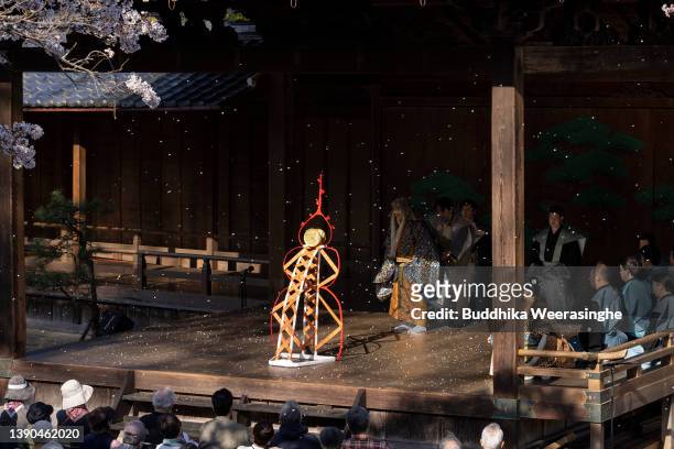 Professional ‘Noh’ drama actors perform while cherry blossoms are in full bloom to celebrate the flower viewing tradition on a traditional outdoor...