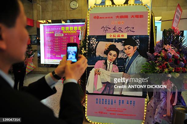 Entertainment-HongKong-art-opera-heritage,FEATURE BY Lih Yi BEH A man takes a picture of a poster advertising Chinese opera, standing inside of the...