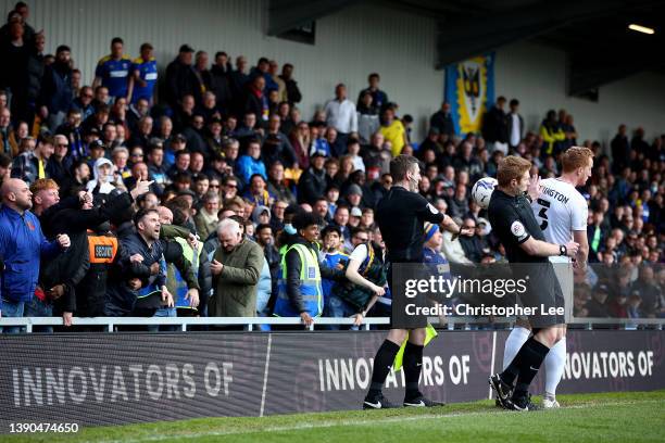 Fans throw the match ball back onto the pitch during the Sky Bet League One match between AFC Wimbledon and Milton Keynes Dons at Plough Lane on...