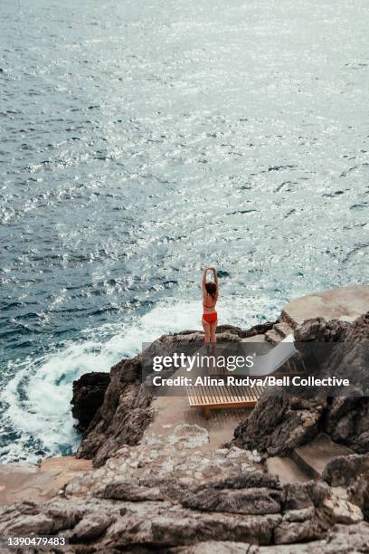 woman stretching by the sea - beach lounger stock-fotos und bilder