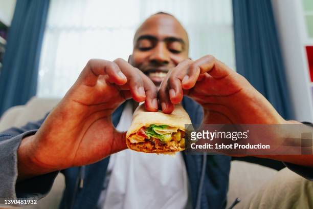 man eating chicken burrito, wide shot pov. - burrito 個照片及圖片檔