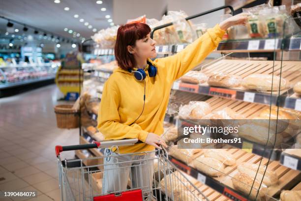 young caucasian woman doing her shopping in supermarket - loaf of bread bildbanksfoton och bilder