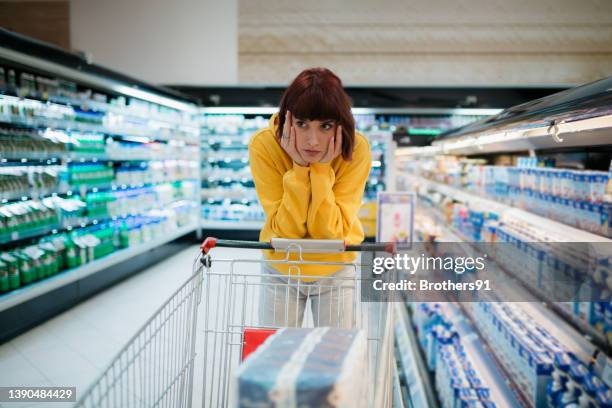 young caucasian woman doing her shopping in supermarket - 經濟衰退 個照片及圖片檔