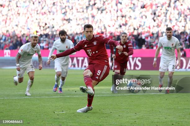 Robert Lewandowski of FC Bayern Muenchen scores their side's first goal from a penalty during the Bundesliga match between FC Bayern Muenchen and FC...