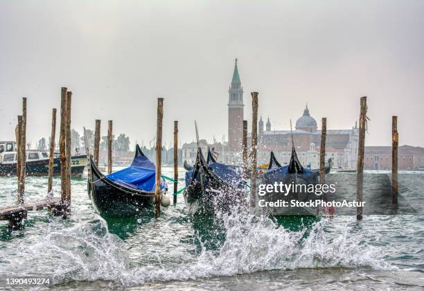 gondolas parked at san marco square with high tide. - alta marea foto e immagini stock