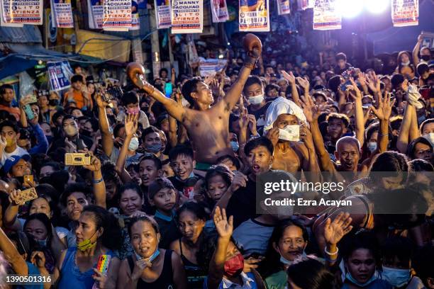 People cheer as senator and boxing icon Manny Pacquiao takes part in a rally in a slum area as he campaigns for the presidency on April 09, 2022 in...