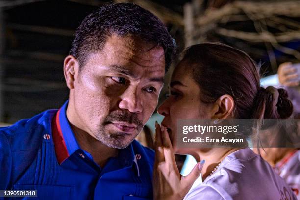 Senator and boxing icon Manny Pacquiao speaks with his wife Jinkee as he takes part in a rally in a slum area as he campaigns for the presidency on...