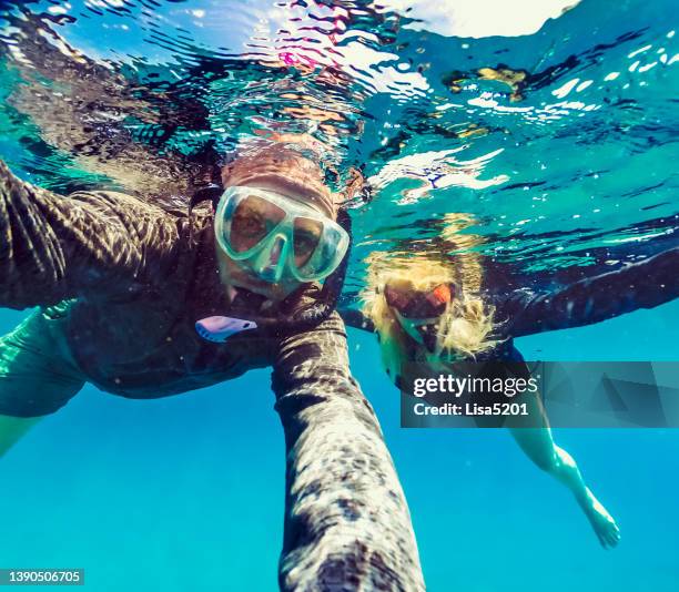 man and woman snorkeling together underwater, tropical ocean, in a fun selfie - curaçao stock pictures, royalty-free photos & images