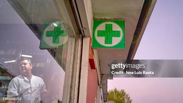 pharmacy neon green cross sign at night - hospital sign stock pictures, royalty-free photos & images