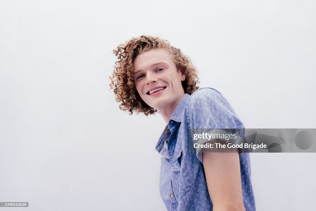 Low angle view of young man standing against white background