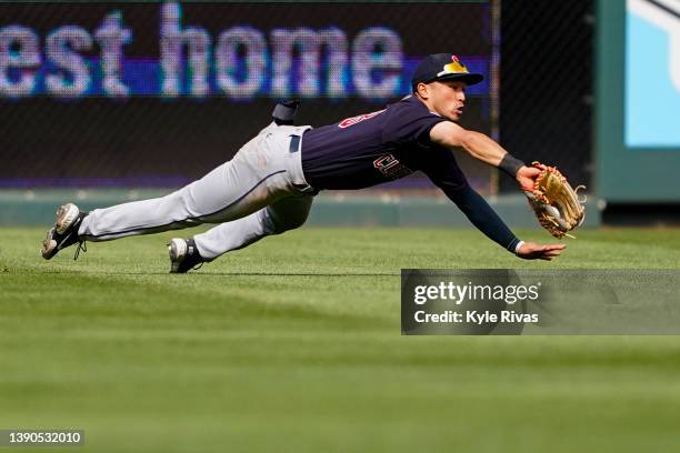 Steven Kwan of the Cleveland Guardians makes a diving catch in left field against the Kansas City Royals to end the third inning at Kauffman Stadium...