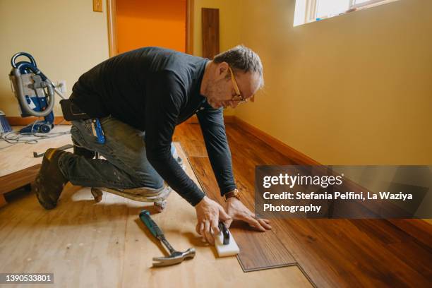 man installing wood floor - wood worker posing ストックフォトと画像