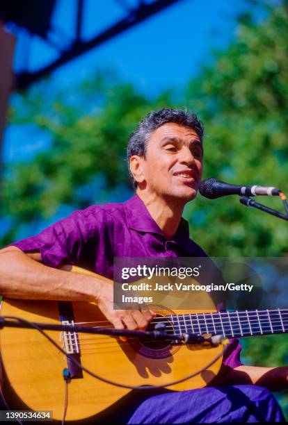 Brazilian composer & musician Caetano Veloso plays acoustic guitar as he performs at Central Park SummerStage, New York, New York, June 23, 1996.