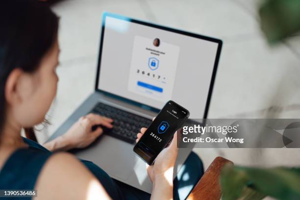 businesswoman using laptop and mobile phone logging in online banking account - segurança do trabalho imagens e fotografias de stock