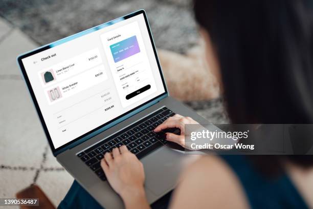 woman shopping clothes online on laptop and making payment with credit card - bank card mock up stockfoto's en -beelden