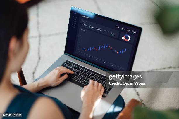 woman trading stocks, cryptocurrency and managing financial investment on laptop - tablet screen home stock-fotos und bilder