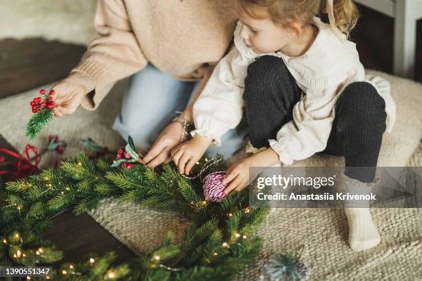 family making christmas wreath at cozy home. - wreath making stock pictures, royalty-free photos & images