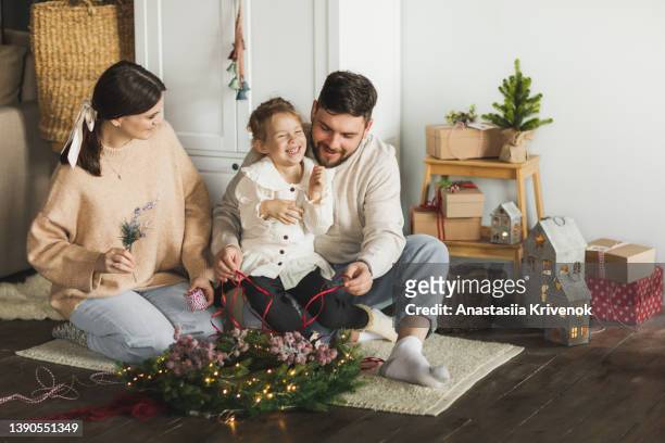 family making christmas wreath at cozy home. - craft room stock pictures, royalty-free photos & images