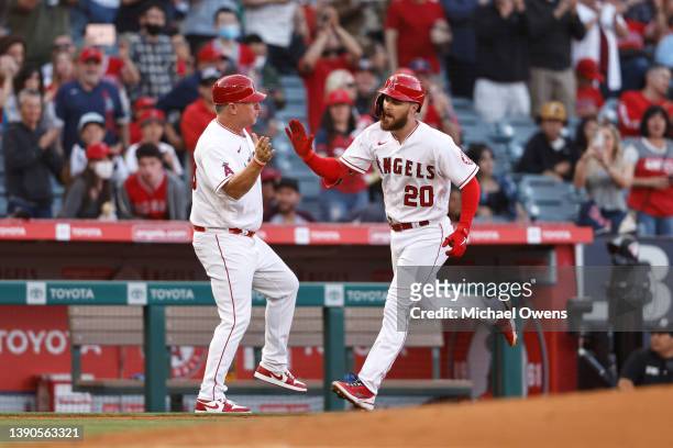 Jared Walsh of the Los Angeles Angels celebrates with third base coach Phil Nevin as he rounds third base after hitting a solo home run against the...