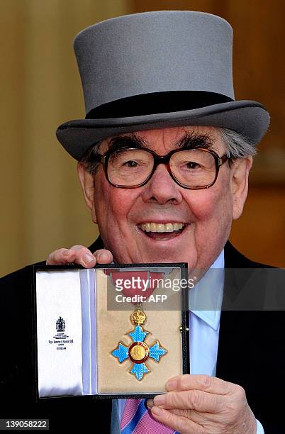 British comedian Ronnie Corbett poses with his medal after he received the honour Commander of the Order of the British Empire from Britain's Queen...