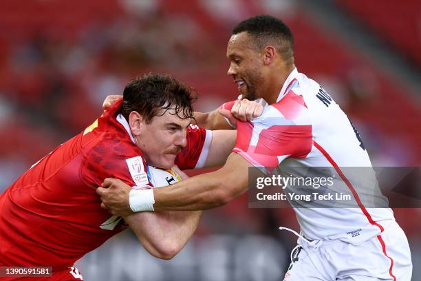 Phil Berna of Canada runs with the ball against Dan Norton of England in the first half of their 13th place semifinal match during the HSBC Singapore...