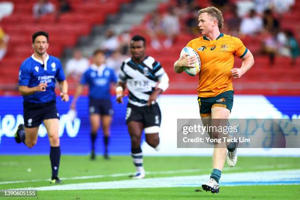 Henry Hutchison of Australia scores a try against Fiji in the first half of their cup semifinal match during the HSBC Singapore Rugby Sevens at the...