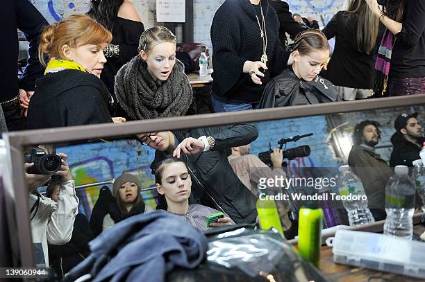 Models prepare backstage before the threeASFOUR Fall 2012 fashion show during Mercedes-Benz Fashion Week at the The Hole on February 15, 2012 in New...