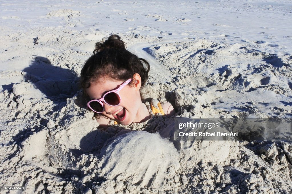 Young Girl Is Buried Up To Her Head In Sand At The Beach High-Res Stock ...