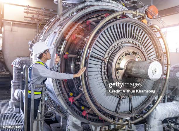 engineer working with gas turbine at industrial zone, workers inspect turbine in power station, power plant equipment, worker checks turbine impeller vanes on factory - turbina a gas foto e immagini stock