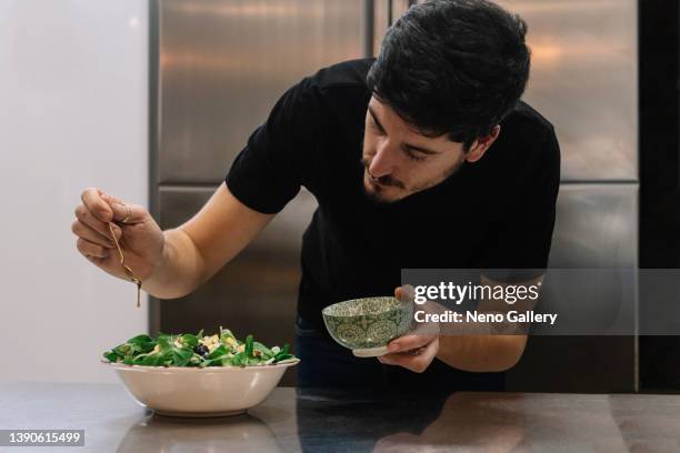 cook pouring sauce on top of a salad - savory sauce fotografías e imágenes de stock