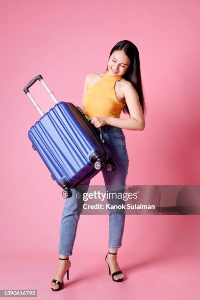 woman carrying suitcase while standing against pink background - 2021 a funny thing stock pictures, royalty-free photos & images