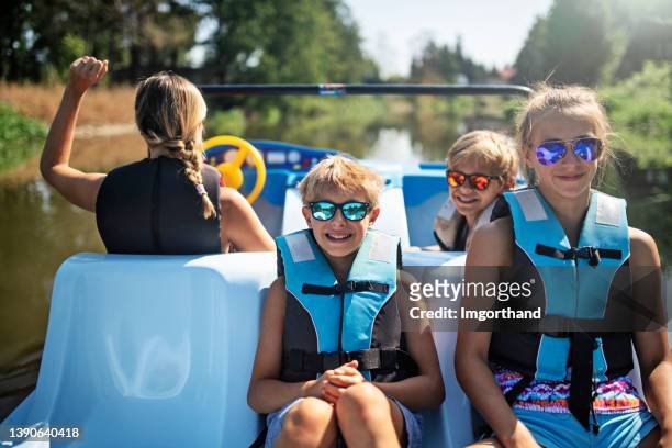 family enjoying riding a pedalo on a river - paddleboat stock pictures, royalty-free photos & images