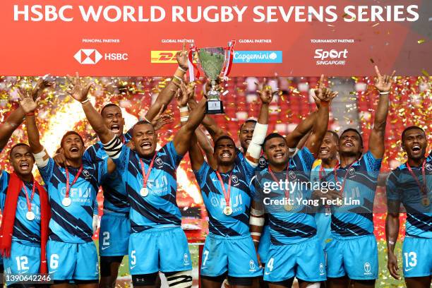 The Fijian team celebrates with the winners' trophy after their cup final victory against New Zealand during the HSBC Singapore Rugby Sevens at the...