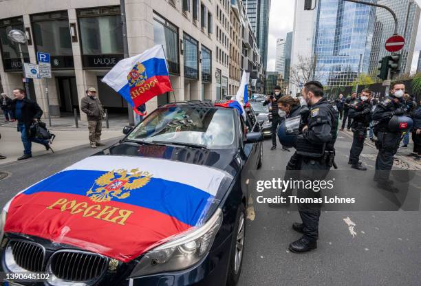 Police officers demand to remove the russian flag from a car of protesters on the way to a demonstration o show their support for Russia that was...